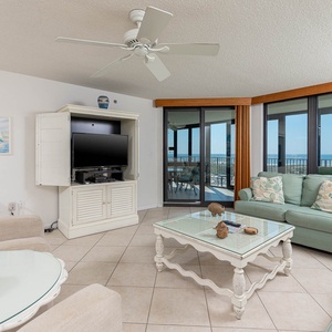 Living area features a light green sofa with queen sleeper, glass coffee table, and expansive views of the gulf