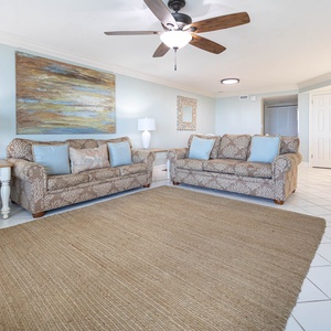 Bright living area featuring two patterned sofas, a textured rug, and a breakfast bar, creating a welcoming vibe