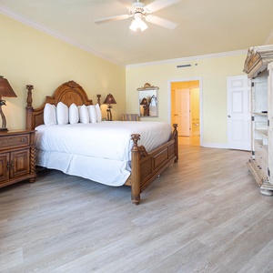 Retreat to the spacious master bedroom featuring a king bed, elegant furnishings, and a cozy seating area for relaxation