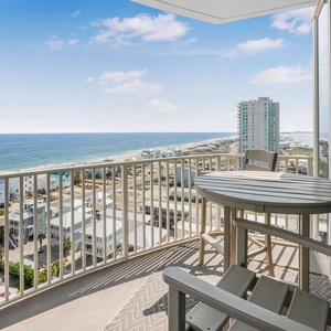 Relax with stunning beach views from this balcony featuring a round table and chairs, perfect for relaxing moments