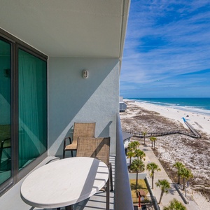 Quiet moments await on your balcony where you watch beachgoers stroll under a clear blue sky