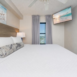 Fluffy pillows invite you to relax in the king suite for a calm movie night after a fun day at the beach