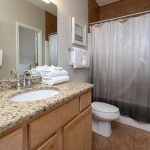 Refresh in this bathroom featuring a spacious granite countertop, soft towels, and a relaxing shower area