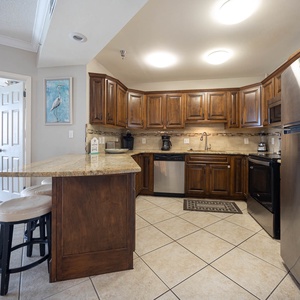 Spacious kitchen with rich wood cabinetry, stainless appliances, and a coffee corner with Keurig and traditional pot