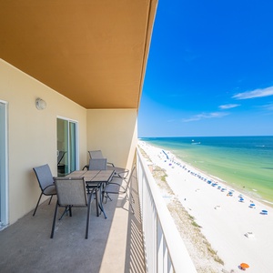 Expansive views from the balcony, complete with a dining table and chairs overlooking the pristine beach
