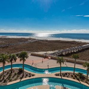 Feel the coastal breeze while lounging on the balcony, taking in serene views of the sparkling shore and pool below