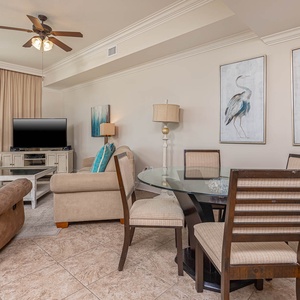 The inviting living area features a large TV, comfortable seating, and a dining table, perfect for relaxing by the beach view