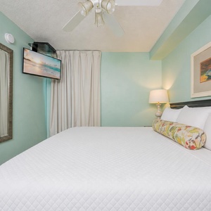 Fluffy pillows invite you to relax in the king suite for a calm movie night after a fun day at the beach