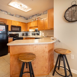 Gather around the inviting kitchen bar with wooden stools, perfect for casual meals and conversation