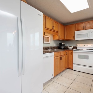 Bright wood cabinetry complements the spacious kitchen, featuring a convenient breakfast bar