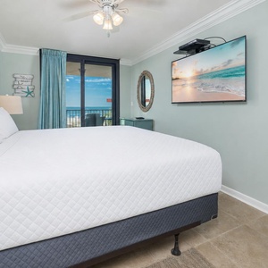 Tranquil master bedroom with a king bed and a TV, plus sliding doors that open to stunning beach views