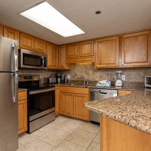 Cook meals with ease in this spacious kitchen featuring stainless appliances and wooden cabinetry