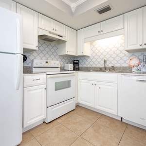 Bright kitchen featuring white cabinetry, granite countertops, and a coffee maker for your morning brew
