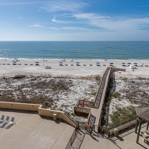 Enjoy stunning views of the serene beach and vibrant blue umbrellas from this inviting outdoor terrace