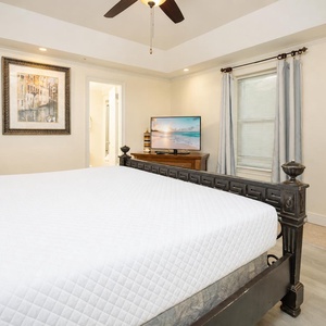 Relax in this inviting guest bedroom featuring a king bed, a TV for entertainment, and tasteful artwork on the walls