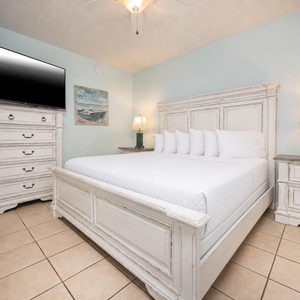 Unwind in the serene bedroom featuring a plush king bed, stylish furniture, and calming blue accents for a restful stay