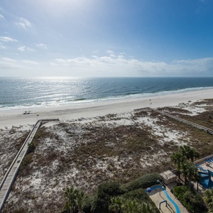 Gaze at the tranquil shoreline and shimmering water, inviting you to soak up the sun