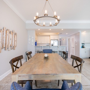 Gather at the large wood dining table under the chandelier for family meals or a fun game night