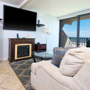 This inviting living area features a cozy seating arrangement and stunning beachfront views through the large sliding doors