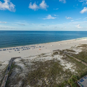 Tranquil waters and expansive coastline, where colorful umbrellas invite relaxation and enjoyment