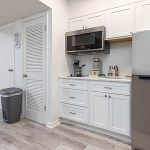 The kitchen features sleek white cabinetry, stainless appliances, and a convenient layout for preparing meals