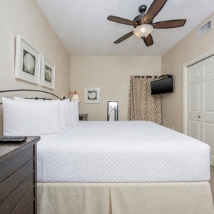 Inviting bedroom featuring a king bed, soft lighting, and a wall-mounted TV, creating a relaxing retreat for guests