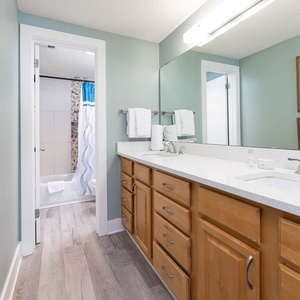 Refresh in the master bathroom featuring dual sinks, modern fixtures, and a relaxing tub-shower combination