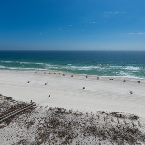 The endless stretch of white sand invites your feet to wander while the shore hums softly nearby