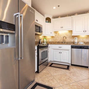 Bright white cabinetry complements the granite countertops in this kitchen, featuring a spacious layout and ample storage
