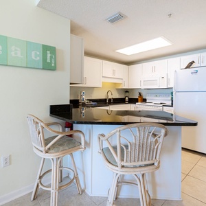 Gather around the sleek black countertop with seating, perfect for casual meals and conversation in the inviting kitchen