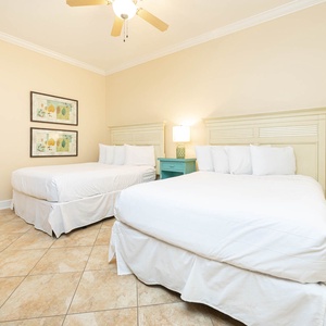 Serene guest bedroom featuring two cozy queen beds, soft linens, and charming coastal decor