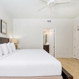 This guest bedroom features a large bed with fluffy pillows, a TV, and a stylish lamp, creating a relaxing retreat