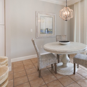 Gather at the charming round table, enjoying laughter and conversation in bright, inviting surroundings