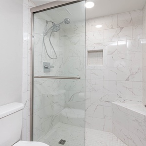 Refresh in the spacious shower in the master bath featuring elegant tile work and sleek design