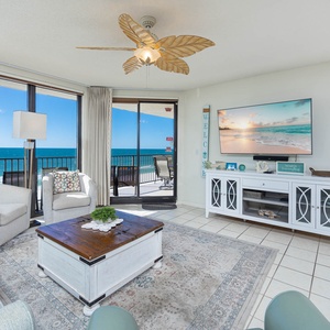 Relax in the inviting living area with comfortable seating and a large TV, all while enjoying the beachfront views