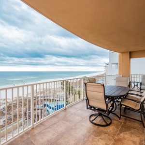 Enjoy the coastal breeze while relaxing at the balcony table overlooking the inviting pool and beach area