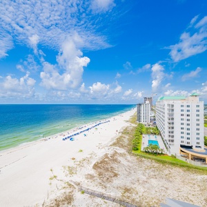 Savor the expansive views from your balcony, overlooking the beach and vibrant blue waters stretching into the horizon