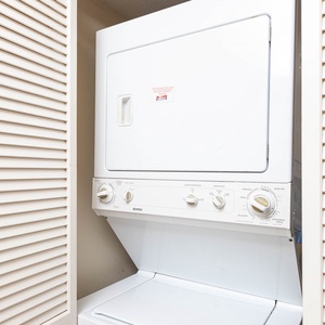 The laundry area features a stacked washer and dryer, providing convenience for guests during their stay