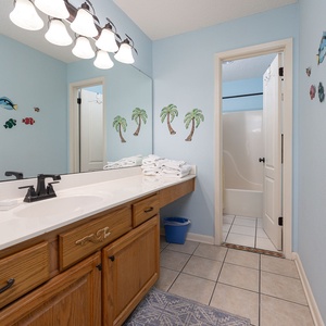 Brightly colored wall decor complements the spacious master bath featuring a large vanity and a tub/shower combo