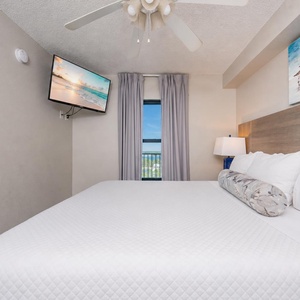 Fluffy pillows invite you to relax in the king suite for a calm movie night after a fun day at the beach