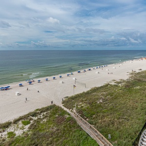 This stunning beachfront view showcases the soft white sand and vibrant blue umbrellas, perfect for a relaxing getaway