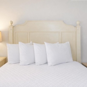 Guest room with a queen bed with plush pillows and a stylish bedside lamp, perfect for relaxation