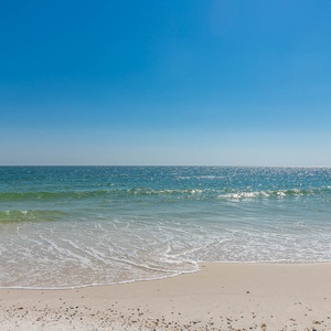 Experience the serene atmosphere with gentle waves lapping at the soft sand, perfect for relaxation and coastal adventures