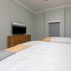 Relax in this guest suite with soft double beds and play streaming shows on the wall TV above the dresser