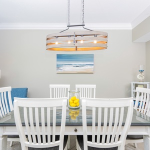 Gather around the dining table, where the coastal decor invites laughter and shared moments with loved ones