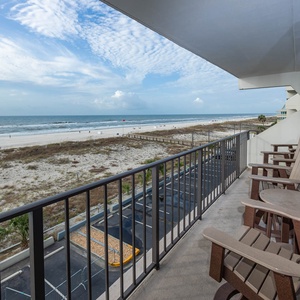 Enjoy stunning beachfront views from this inviting balcony, complete with comfortable seating for relaxation