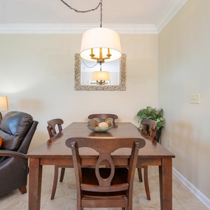 Gather around the wooden dining table set with vibrant placemats, perfect for meals and conversation with loved ones