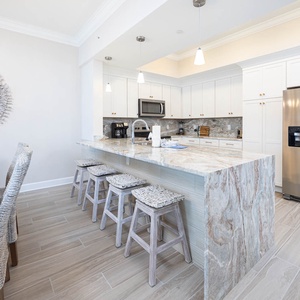 Gather around the elegant dining table or the stylish bar for meals in this inviting kitchen space
