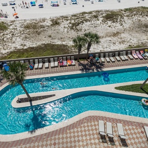 Relax by the inviting lazy river surrounded by palm trees and lounge chairs, just steps from the pristine beach