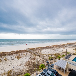 This view showcases a serene beachfront scene with gentle waves lapping at the shore, perfect for relaxation